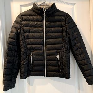 Black packable jacket w/ hidden rain hood under zipper collar. Great for travel!